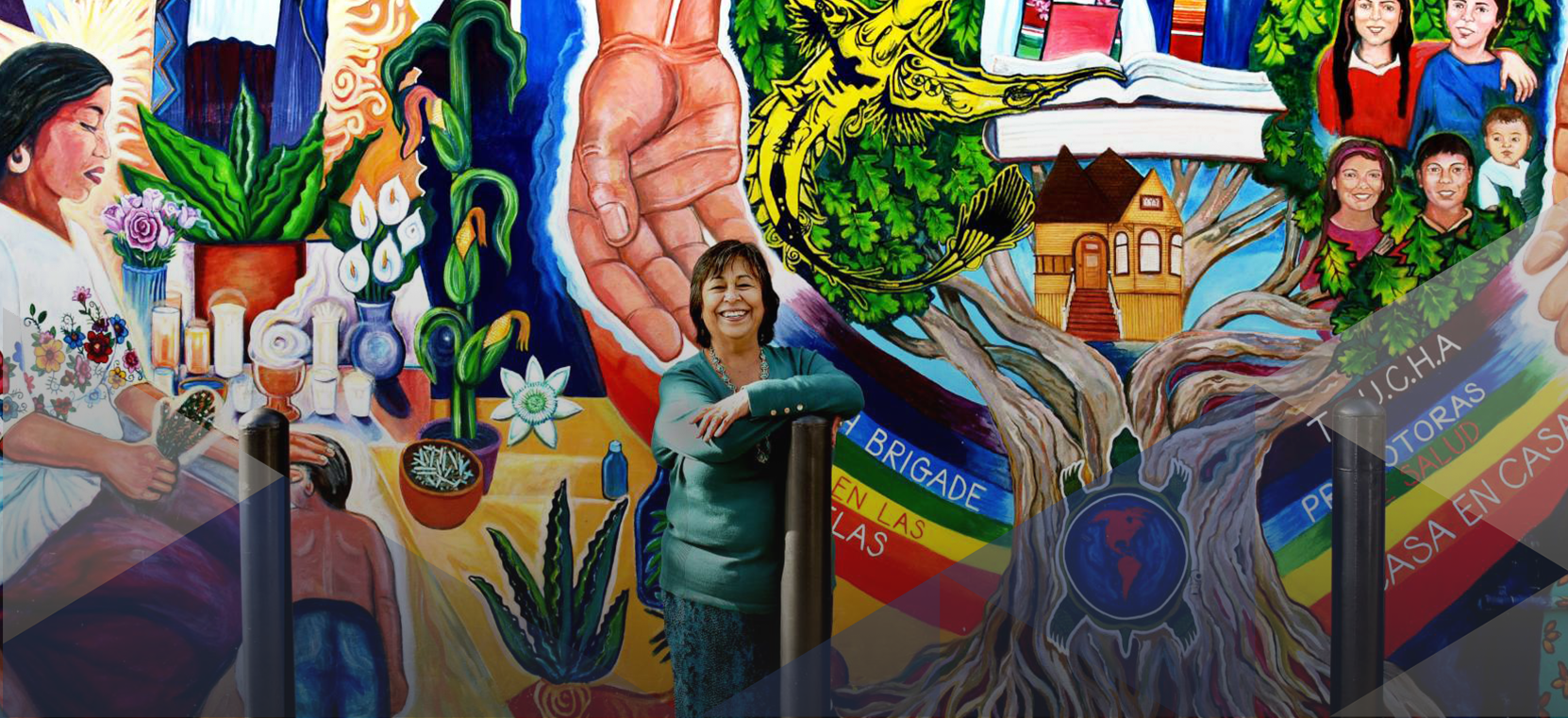 La Clinica de la Raza CEO Jane Garcia stands in front of mural